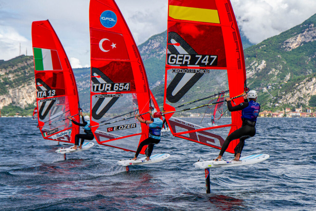 Moritz Schleicher surft auf dem Gardasee gegen zwei Konkurrenten aus der Türkei Italien.