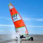 Mit Geschwindigkeiten bis zu 80 Stundenkilometer flitzen Strandsegelnde über die Sandbank in St. Peter-Ording - in einem ausgewiesenen und abgesicherten Areal