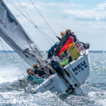 Team 8 Schulboot von hinten bei viel Wind und Schräglage