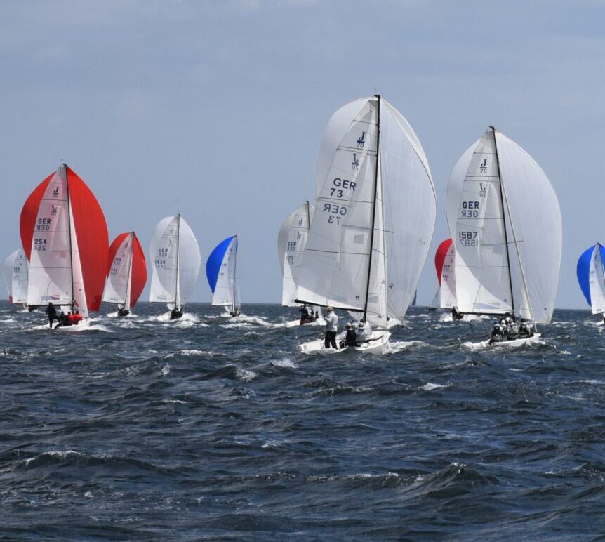 Boote vom Typ J/ 70 unter Spinnaker, man sieht das Heck der Schiffe.