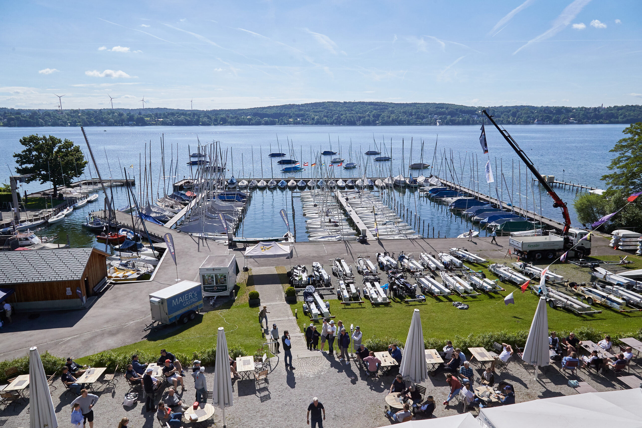 Bild von oben von der Anlage des Münchner Yacht-Club man sieht die Bootstrailer, den Hafen und den flauen See mit ankernden Yachten.