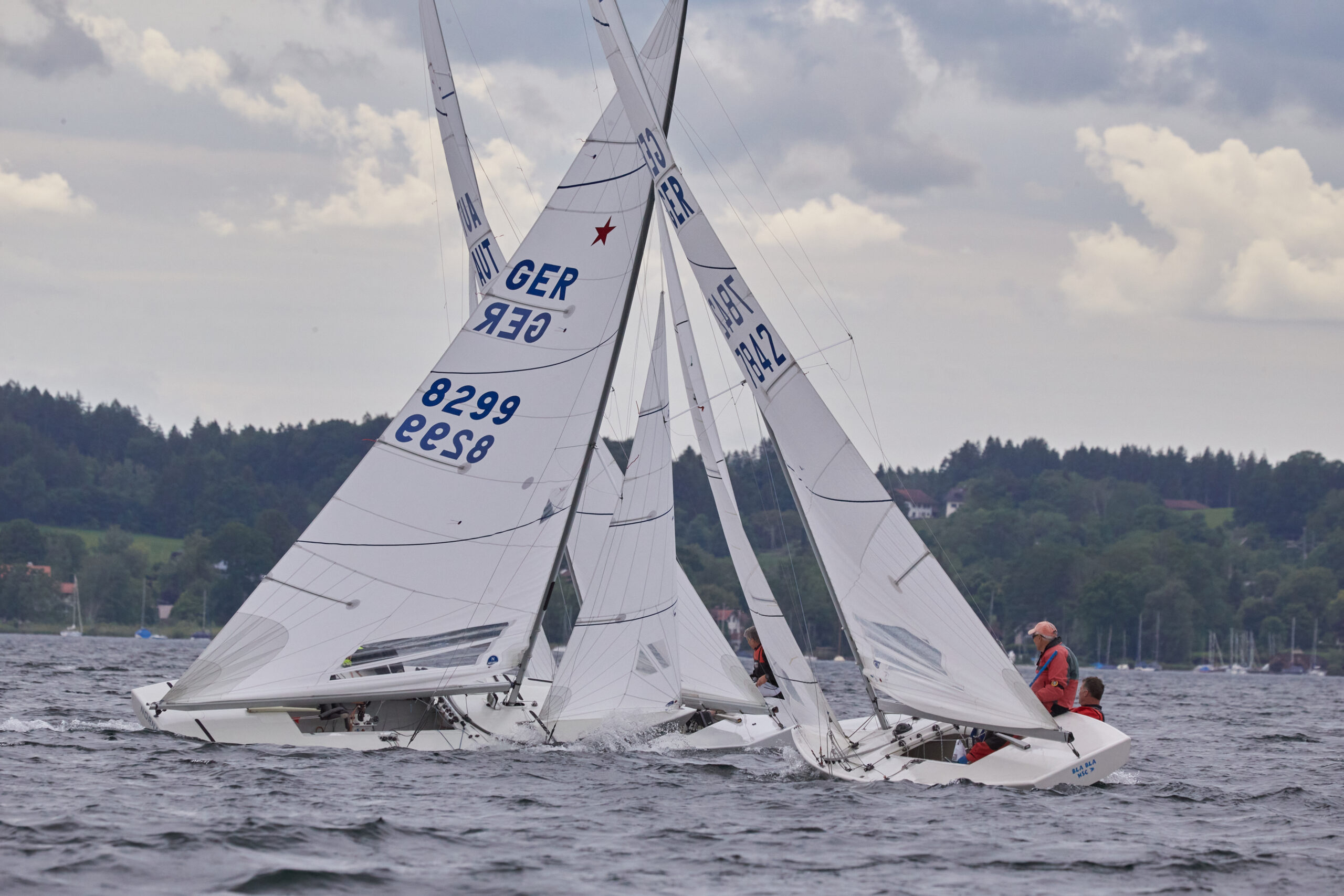 Starboote auf dem Kreuzkurs gegen den Wind deren Kurse sich wiederum kreuzen