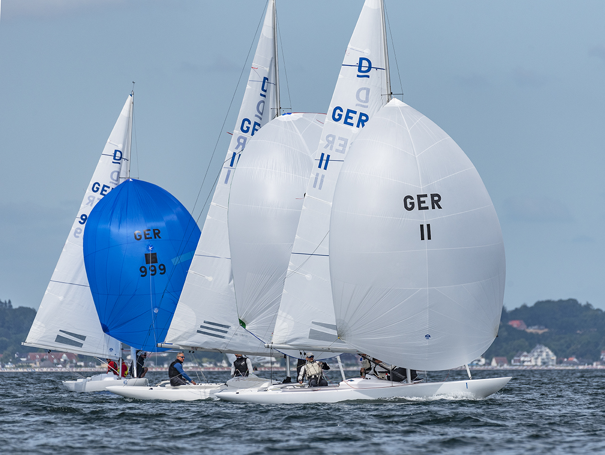 Drei Schiff unter Spinnaker, davon zwei weiße und ein blauer.