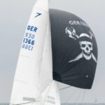 Ein Jolle mit einem schwarzen Spinnacker den ein Piratenkopf ziert.