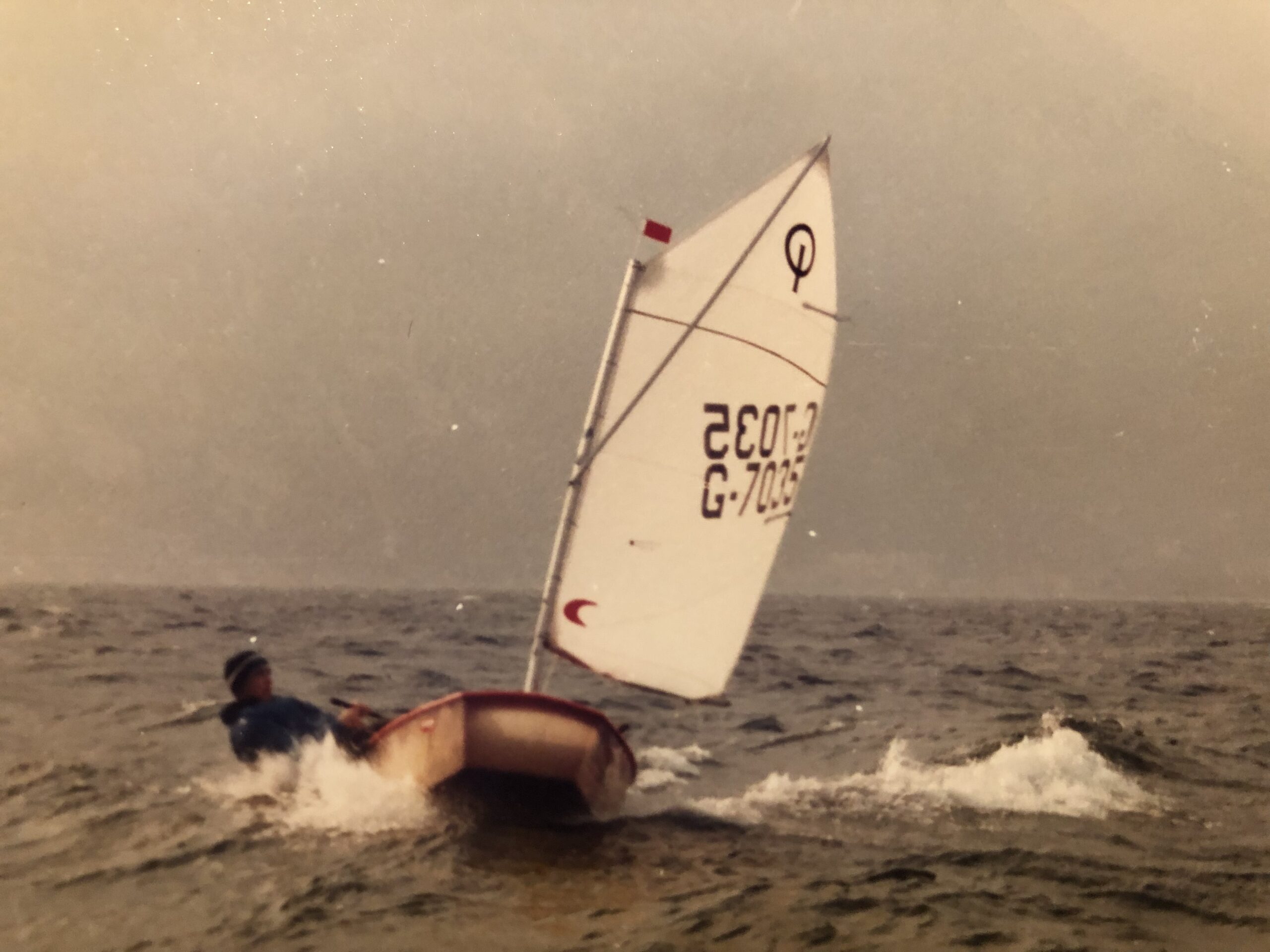 Ein altes Foto in Sepiafarben auf dem die Jüngstenjolle Optimist zu erkennen ist.
