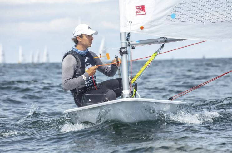 Ein Segler mit dem Trikot des German Sailing Team segelt auf einer Jolle.