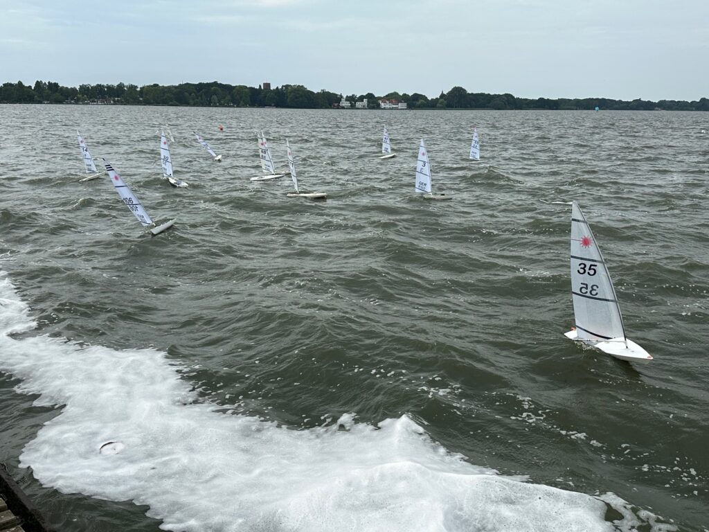 Kleine Modell-Yachten segeln auf dem Wasser, Das Wasser ist sehr unruhig, es hat viele Wellen.