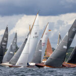 Elegante Holzyachten vor grauen Wolken auf einer Regatta