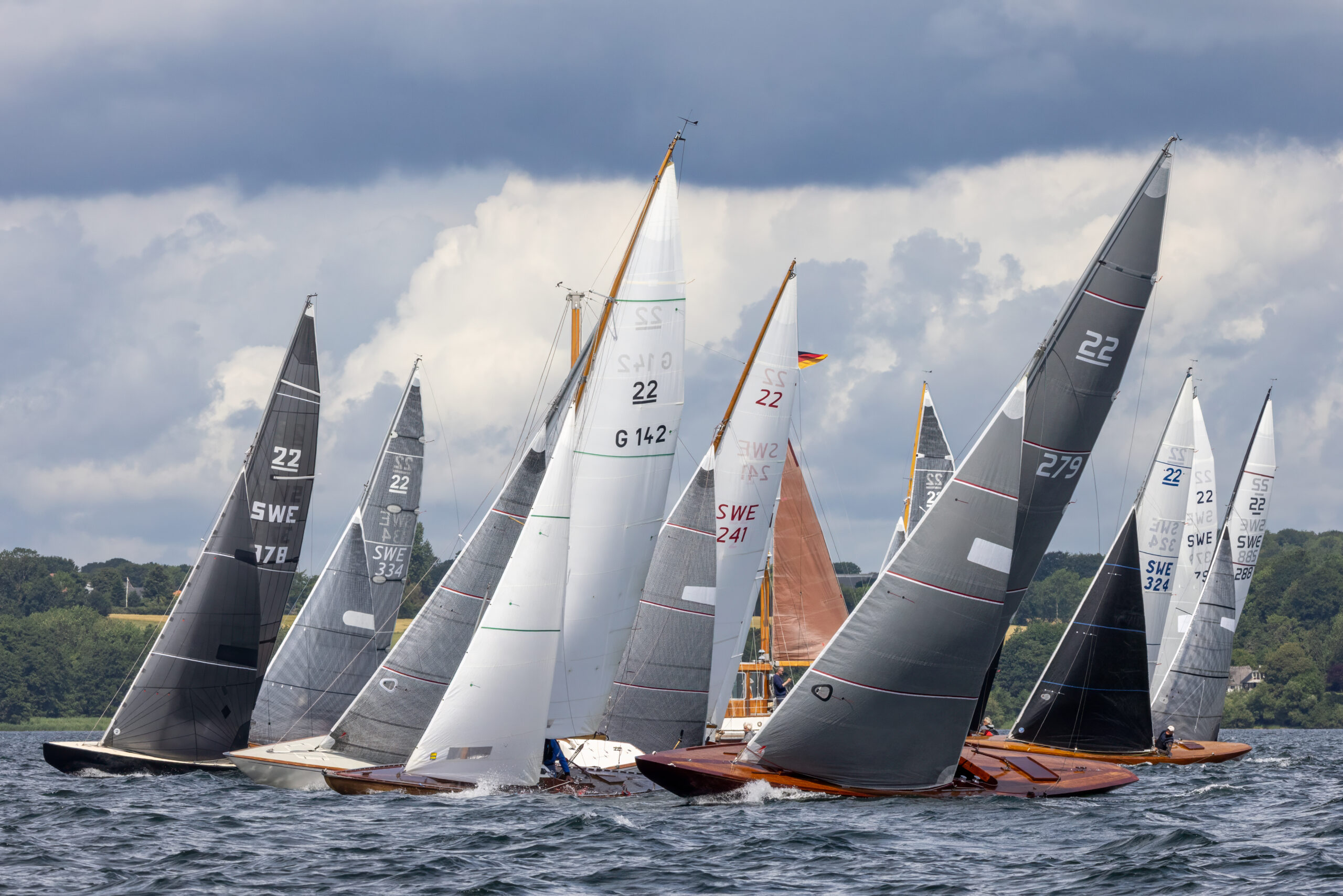 Elegante Holzyachten vor grauen Wolken auf einer Regatta