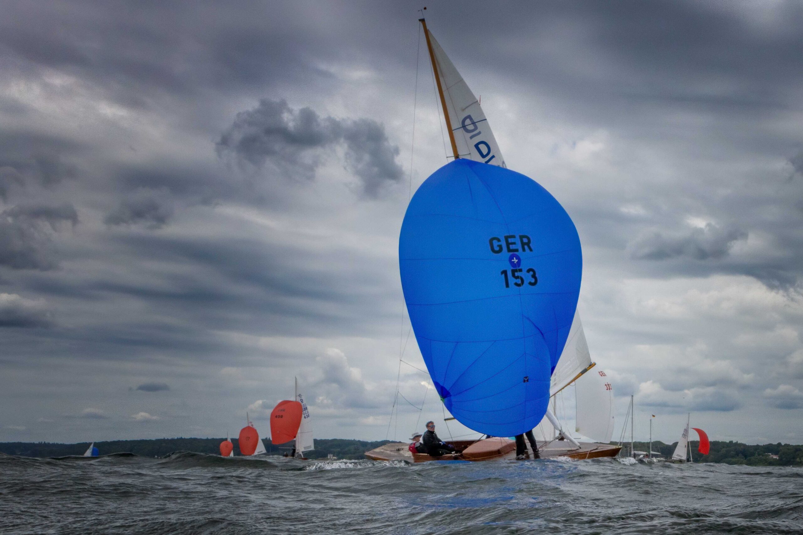Ein Schiff unter Spinnaker mit der Segelnummer 153.