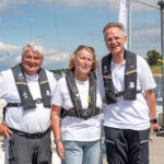 Drei Personen stehen am Steg am Cospudener See und lächeln in die Kamera: Von links nach rechts: Heinz-Peter Schmidt, Mona Küppers und Jens Kroker