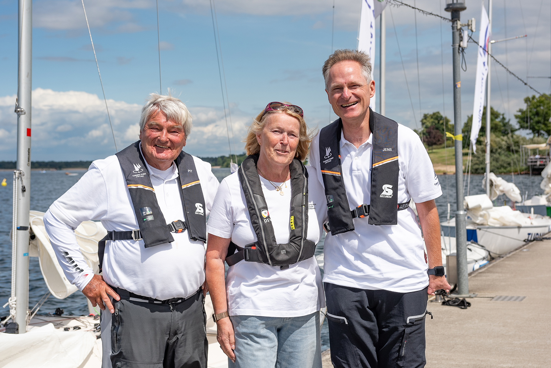 Drei Personen stehen am Steg am Cospudener See und lächeln in die Kamera: Von links nach rechts: Heinz-Peter Schmidt, Mona Küppers und Jens Kroker