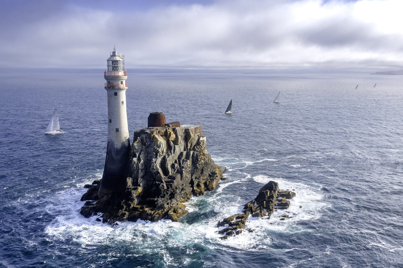 Ein Felsen mit Leuchtturm und Yachten