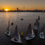 Boote auf der Hamburger Außenalster die bei Sonnenuntergang um eine Tonne herumfahren.