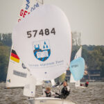 Eine 420er Jolle mit dem Logo eines Schweizer Internats auf dem Spinnaker.