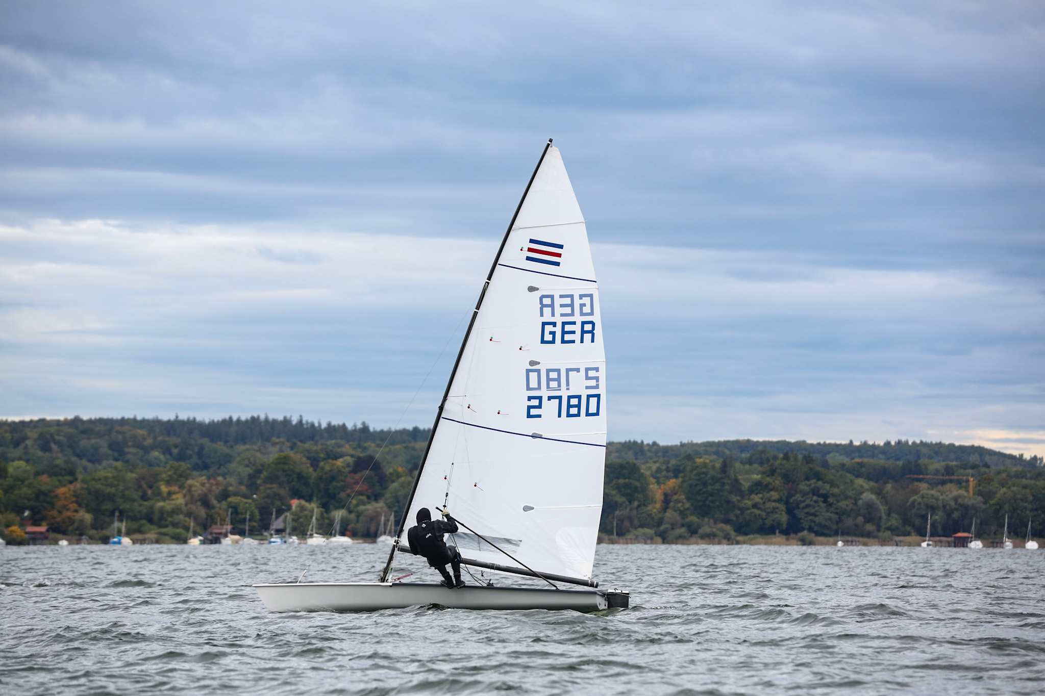 Ein Mann segelt auf einer Jolle für eine Person, die Jolle hat die Segelnummer 2780.