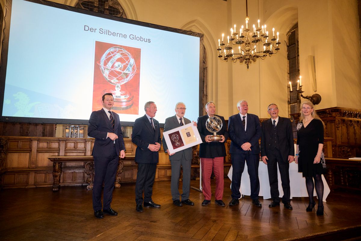 Sechs Männer halten den Wanderpreis "Silberner Globus" für eine Segelreise in den Händen.