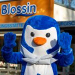 Das Maskottchen der Seglerjugend ist ein Pinguin namens Skippi. Er steht vor dem Namen des Ortes Blossin.