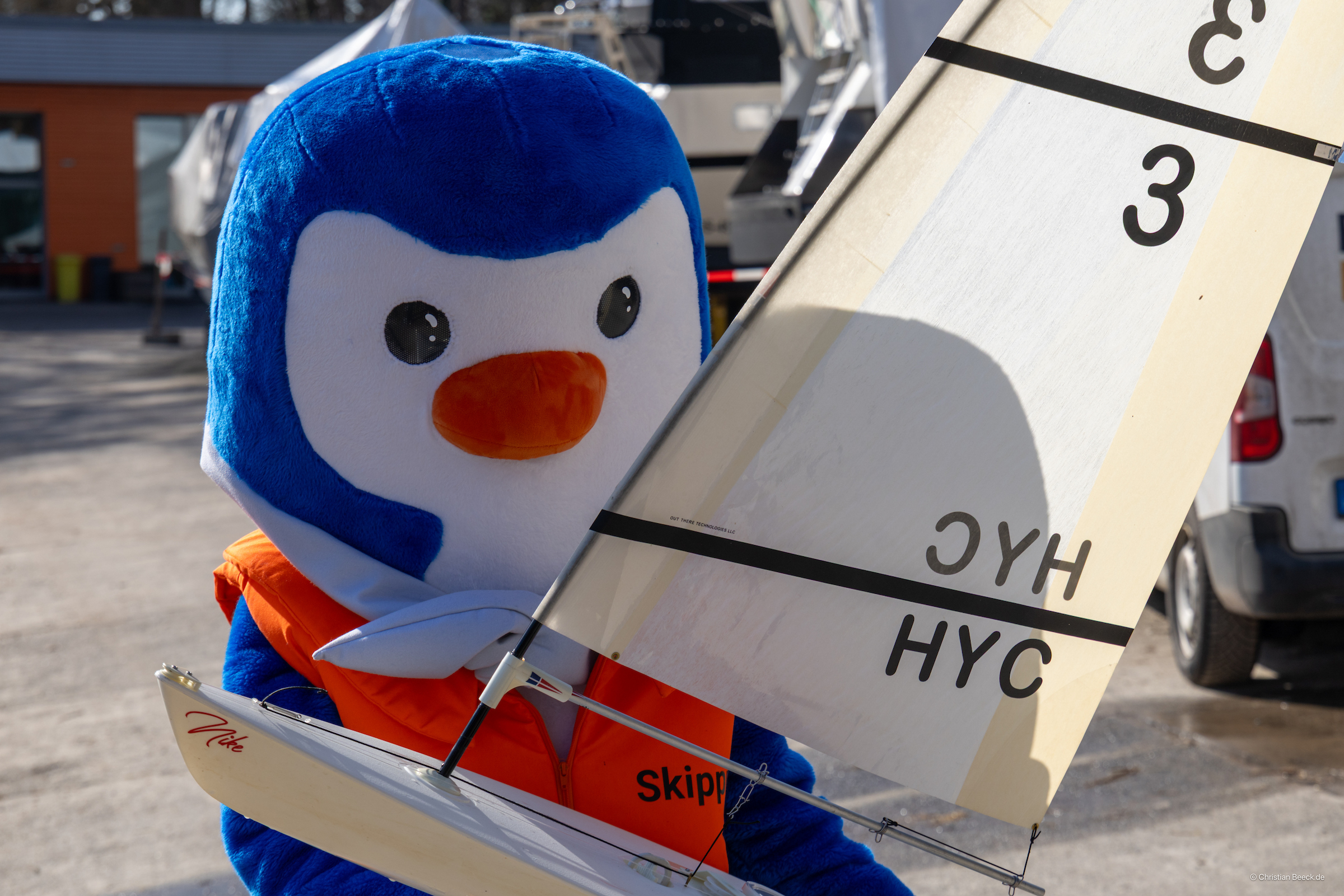 Das Maskottchen der Seglerjugend Skippi mit einer RC Yacht auf dem Arm.