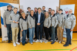 Gruppenfoto des Jugendsegelausschusses: Mehrere Mitglieder stehen nebeneinander und blicken in die Kamera, in ihrer Mitte Jugendobmann Jonathan Koch.
