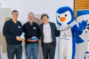 Gruppenfoto mit den Jugendobmänner: Wolfgang Wagner, Timo Haaß, Jonathan Koch stehen neben dem Maskottchen der Seglerjugend „Skippi“, das in die Kamera winkt. Die Jugendobmänner halten jeweils eine kleine Plüschfigur von Skippi in der Hand.