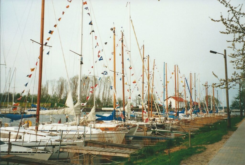 Geschmückte Boote liegen an Stegen.