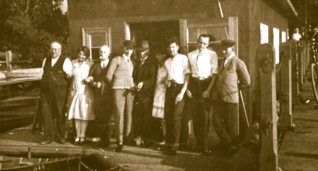 Das historische Foto zeigt Frauen und Männer vor ihrem Bootshaus.