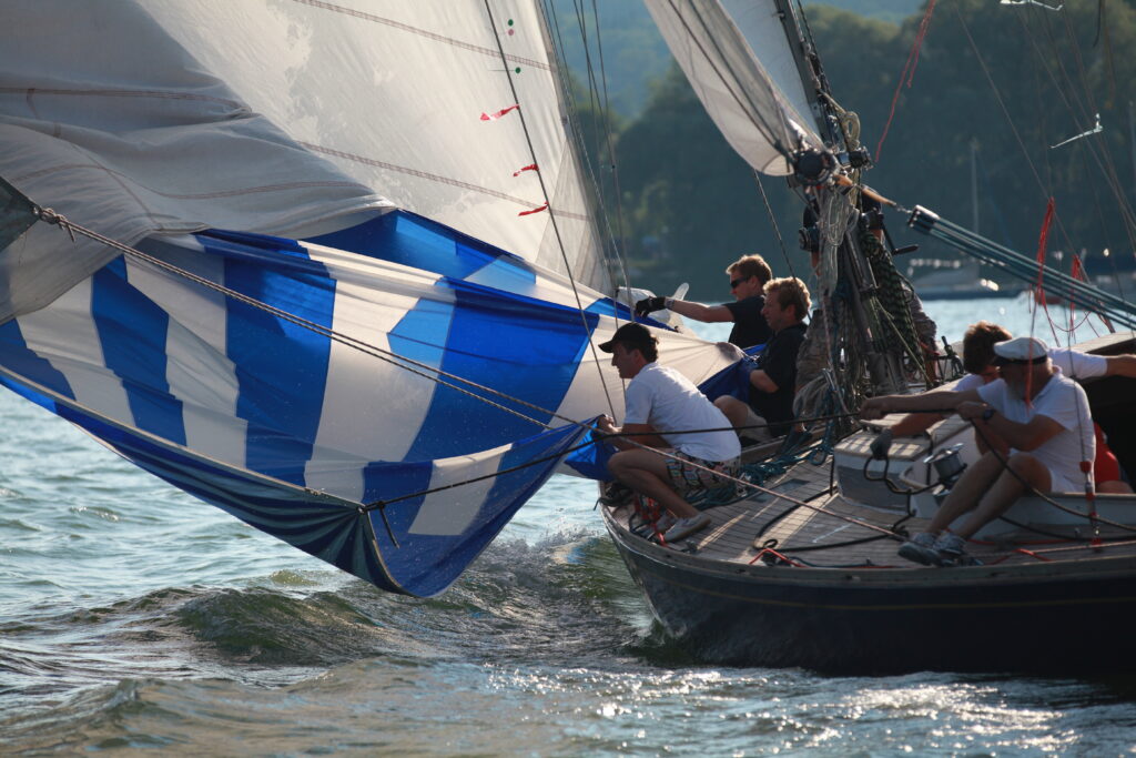 Segler trainieren auf einer großen Yacht, die Segel einzuholen.