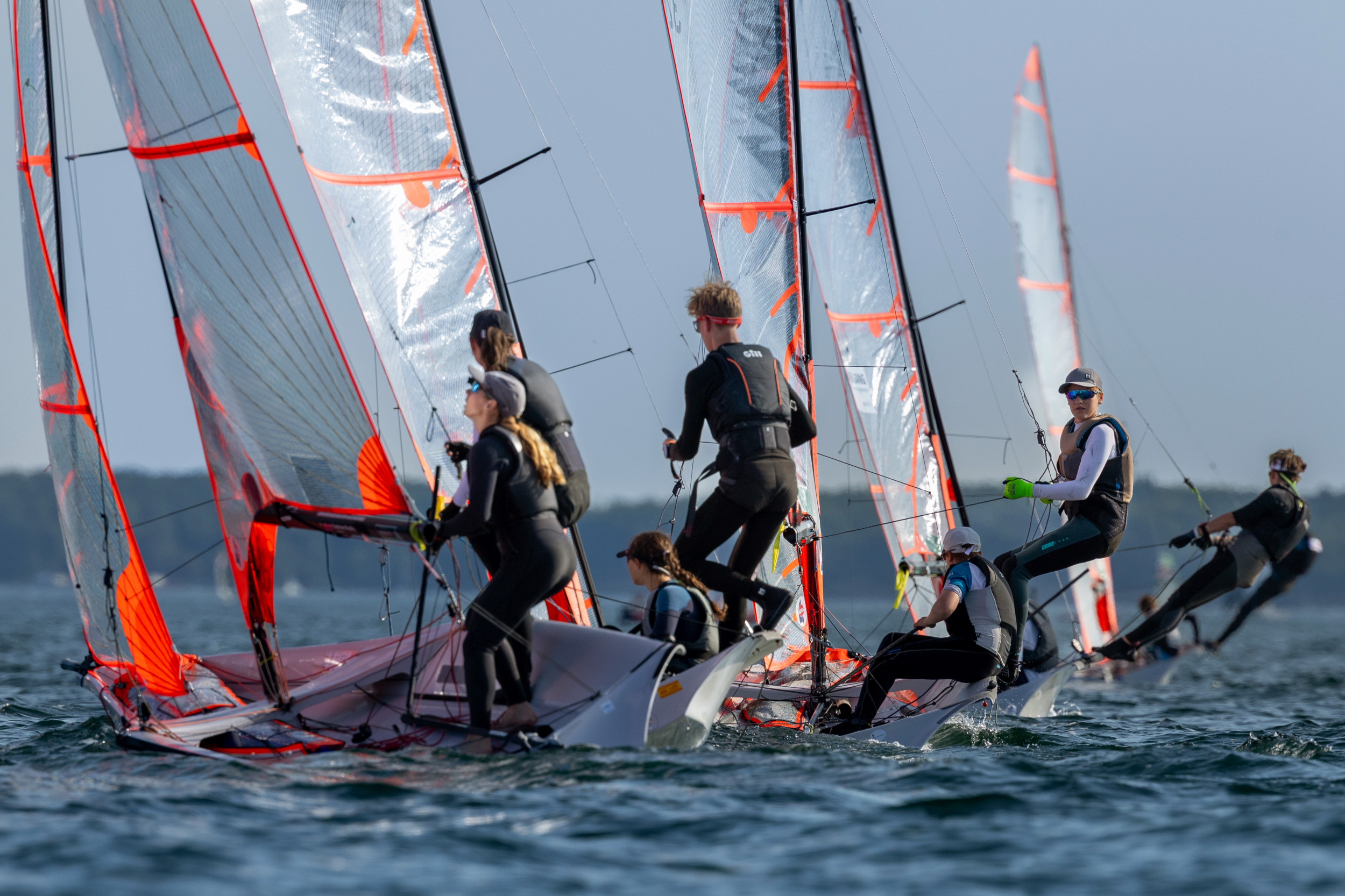 Skiffjollen vom Typ 29er von hinten, die Jollen haben durchsichtige Foliensegel und werden von zwei Personen gesegelt.