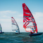 Windsurfer fliegen über das Wasser