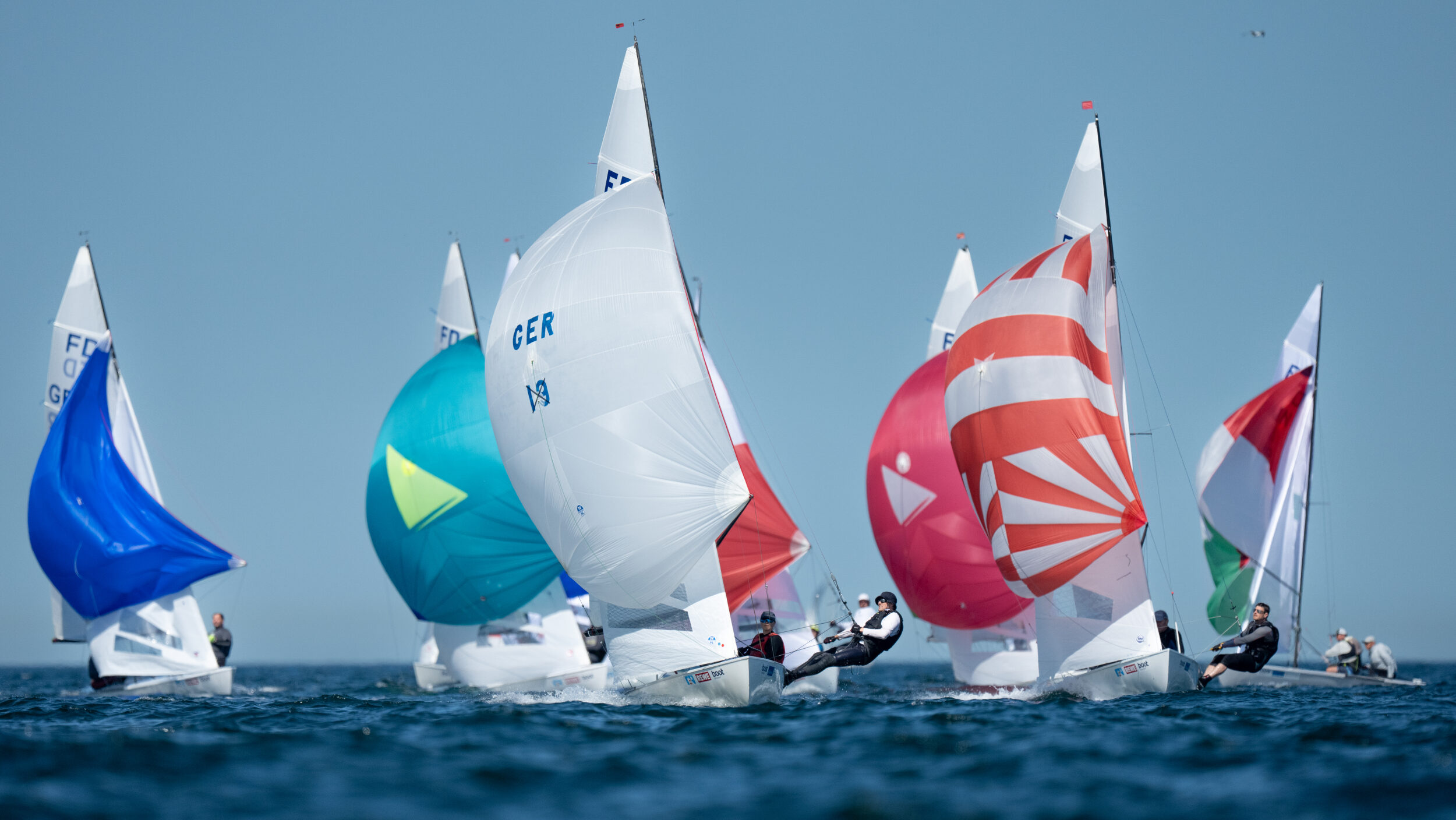 Mehrere Jollen vom Typ Flying Dutchman mit bunten Spinnakern.