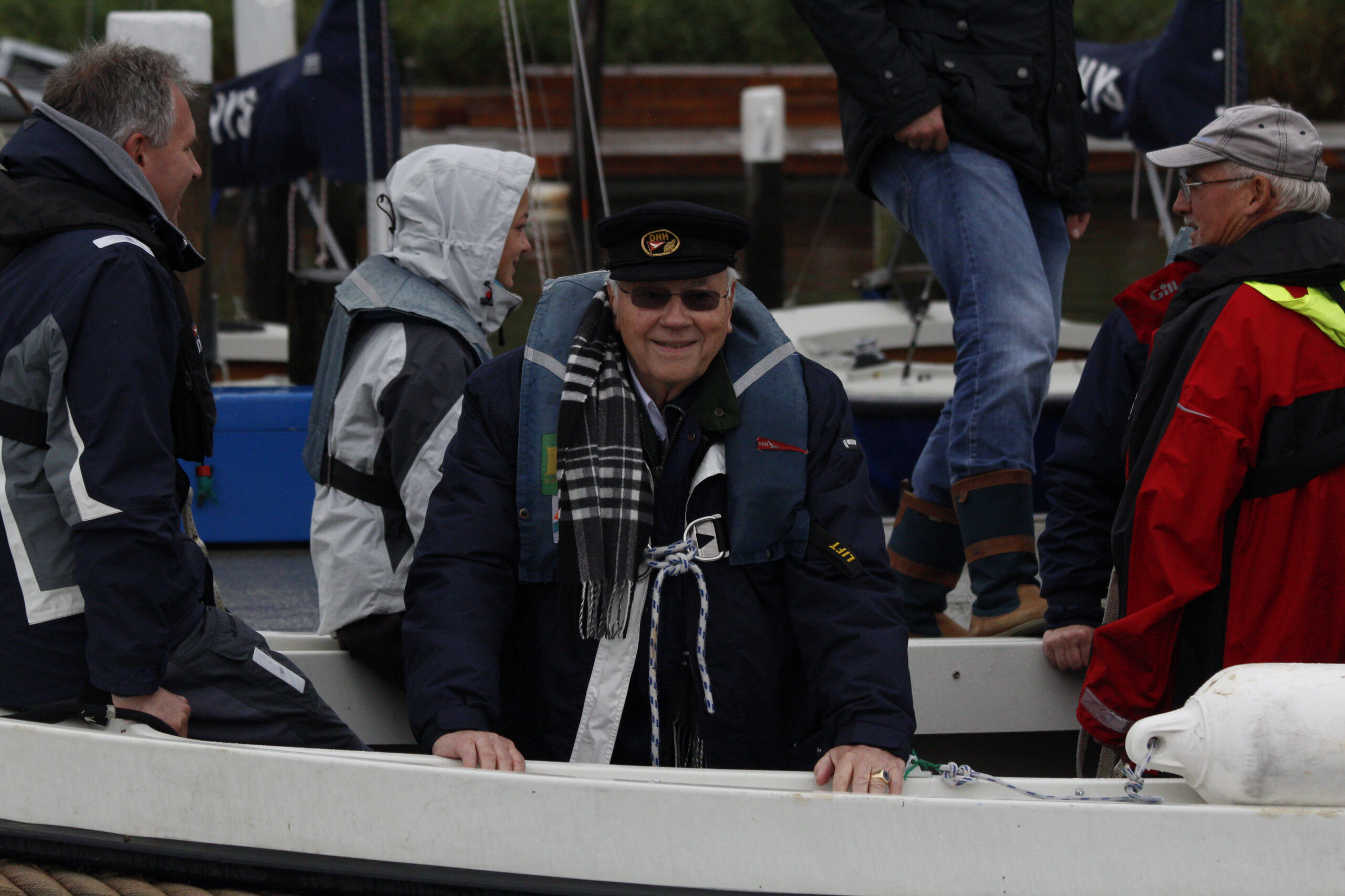 Ein Mann mit einer Schiffermütze und Clubemblem auf einem Boot