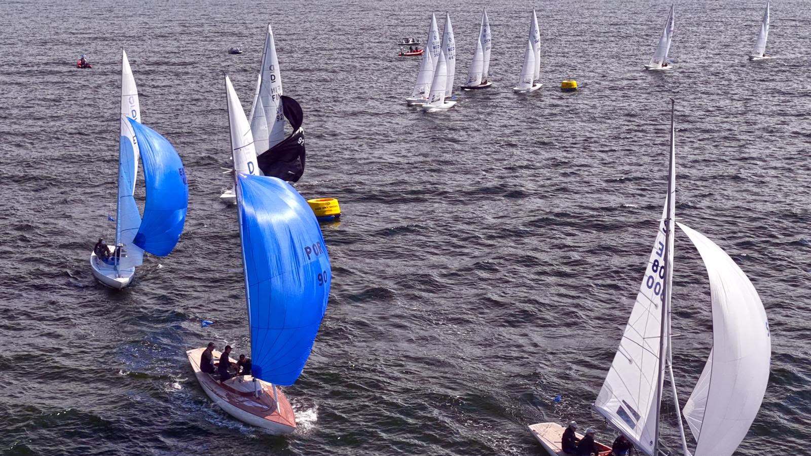 Boote vom Typ Drachen beim runden einer gelben Wendemarke an der der Spinnaker gesetzt wird.