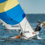 Ein Vorschoter einer Zweierjolle Teeny unter Spinnaker bei viel Wind