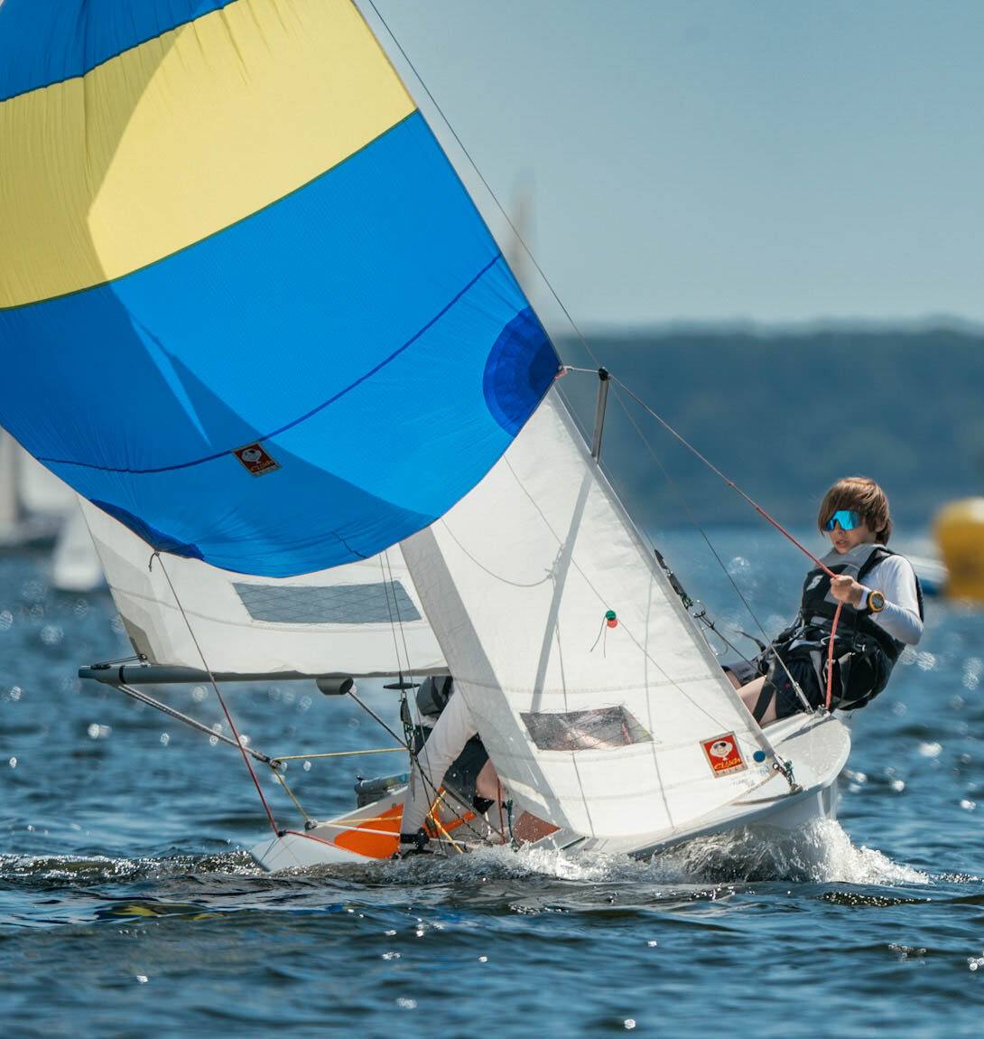 Ein Vorschoter einer Zweierjolle Teeny unter Spinnaker bei viel Wind