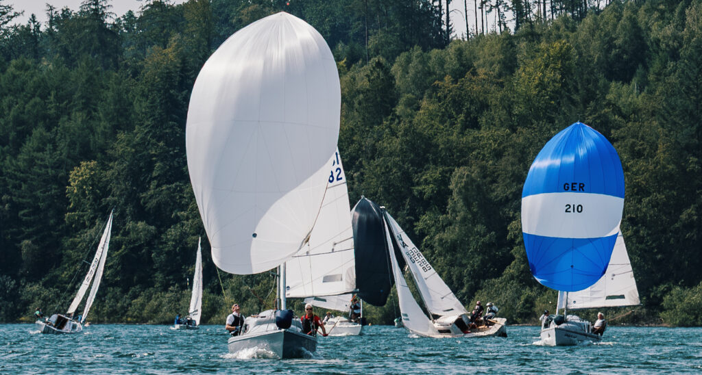 Fünf Varianta-Boote segeln auf dem Sorpesee Regatta. Die zwei Führenden haben bereits den Spinnaker gesetzt