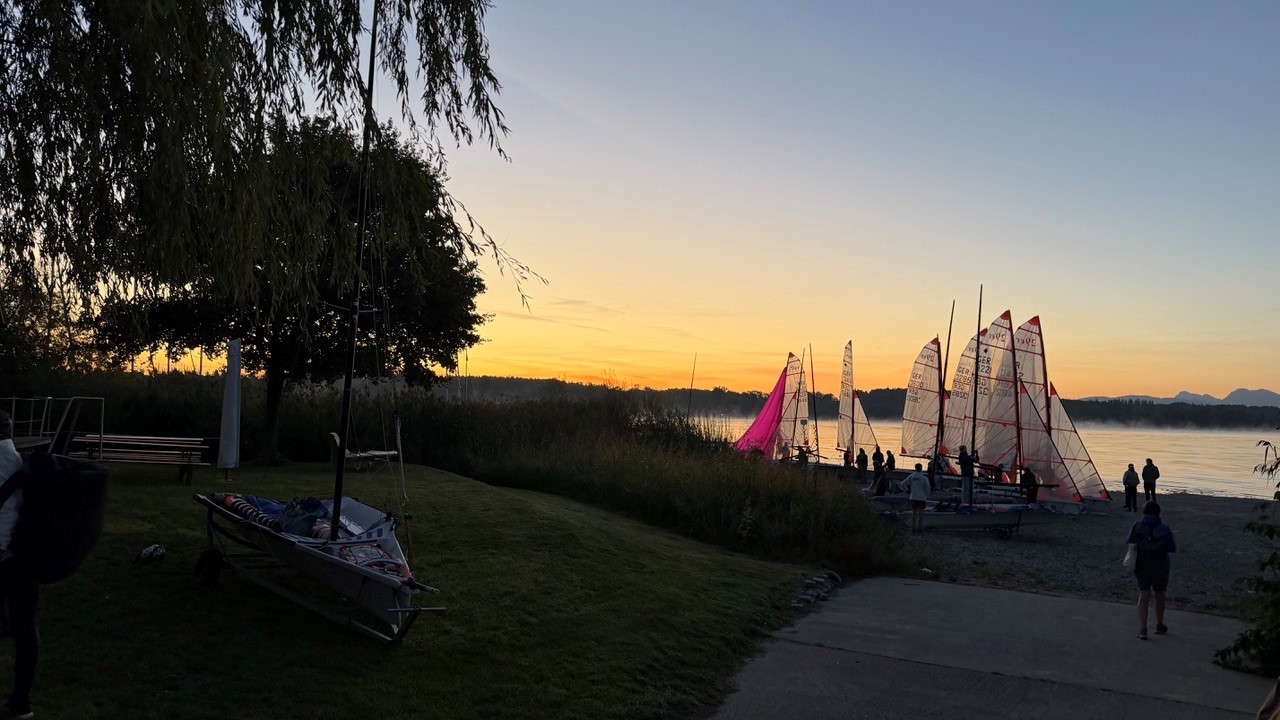 29er Jollen mit durchsichtigen Segeln bei Sonnenaufgang an einem See.