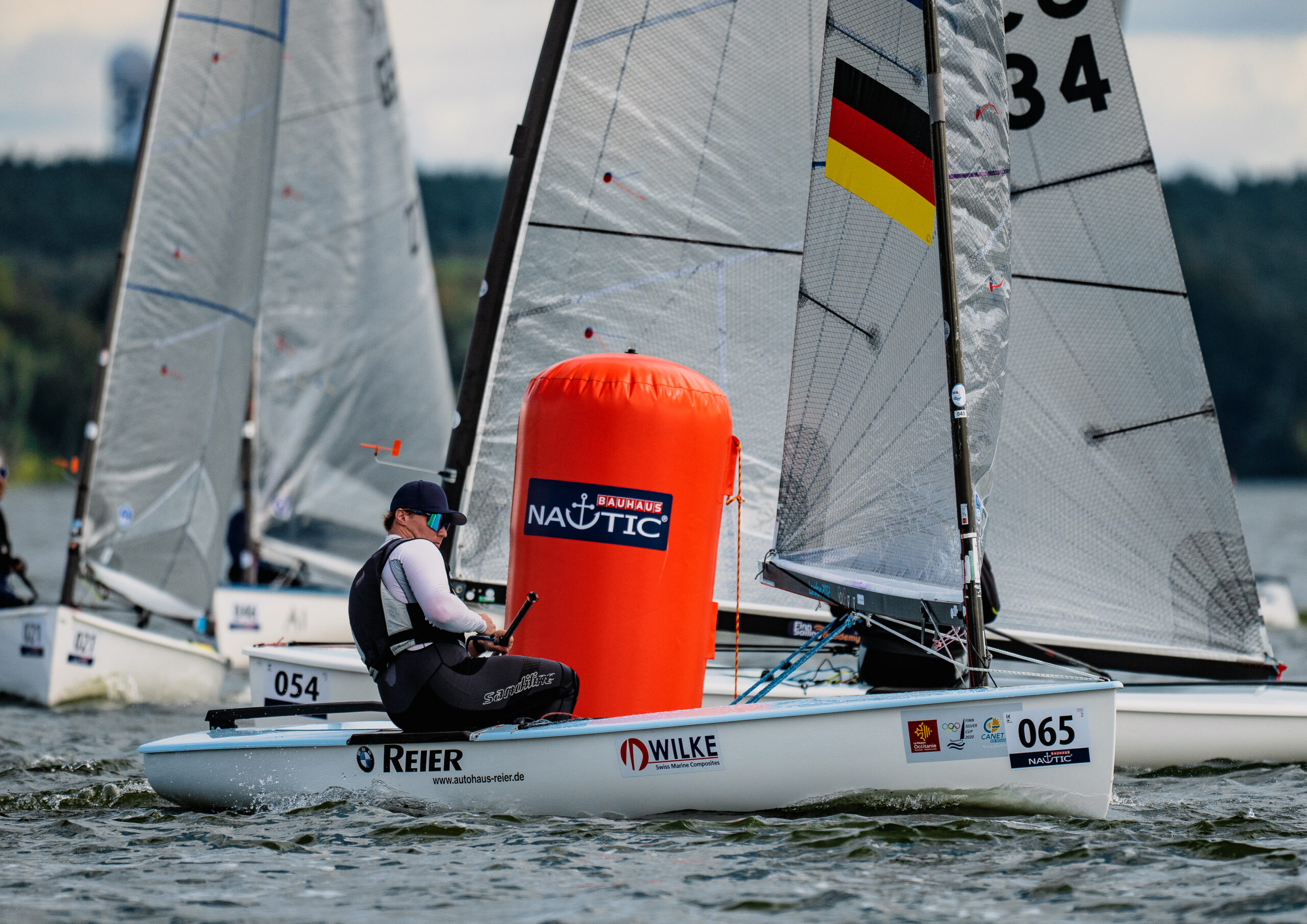 Nicolas Thierse vom Joersfelder Segel-Club rundet eine rote Bahnmarke auf dem Wasser, er segelt Finn Dinghy