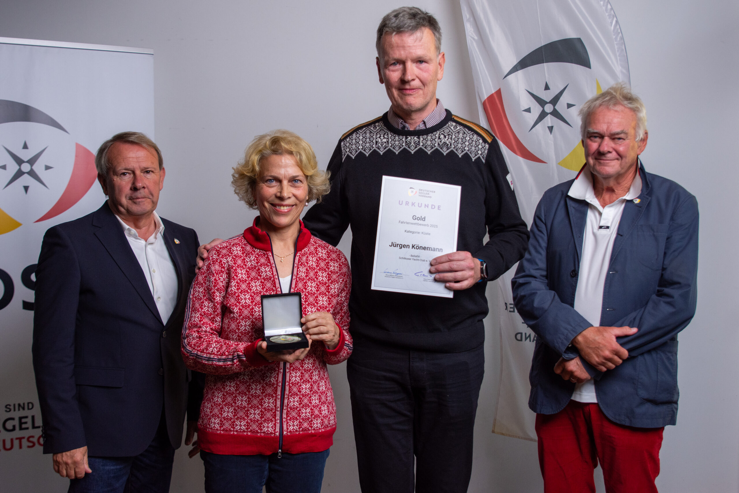 Ein Seglerpaar in Norweger-Pullovern bekommt einen Preis.