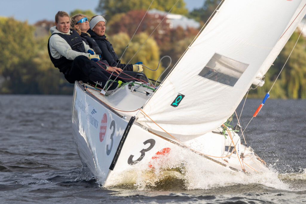 Eine Frauencrew mit drei Seglerinnen segeln bei viel Wind auf der Alster.