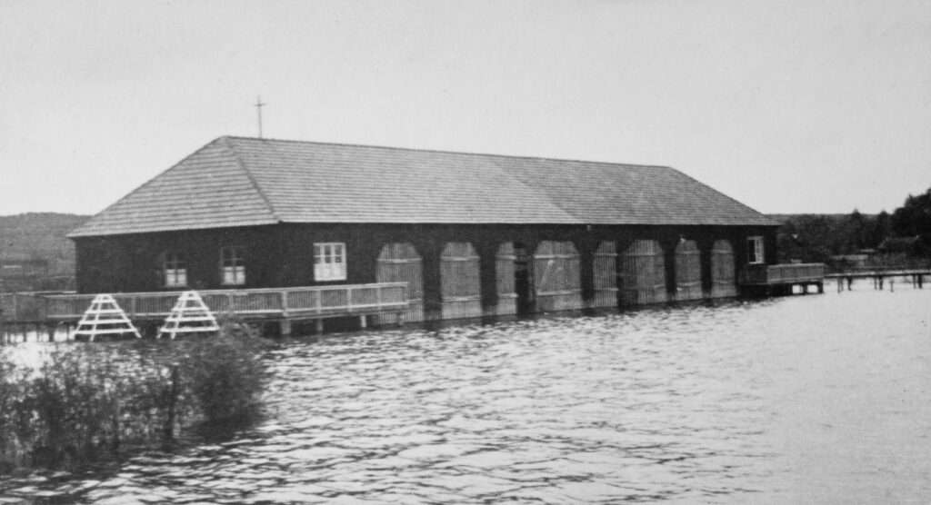 Das historische Clubhaus des DSC vor dem verheerenden Brand. Im alten DSC-Bootshaus konnten bereits 1923 Jollen direkt über dem Wasser aufgeheißt werden. Das war damals eine Besonderheit an den bayerischen Seen. Foto: Vereinsarchiv
